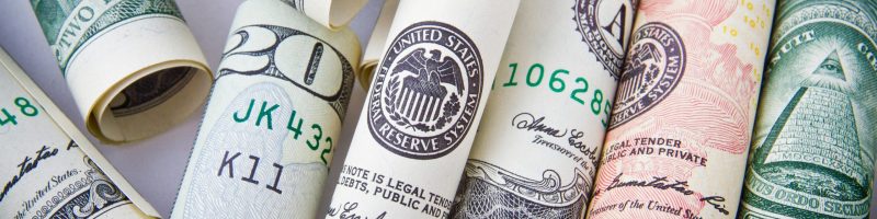 Close-up of rolled US dollar bills symbolizing wealth, financial success, and currency.