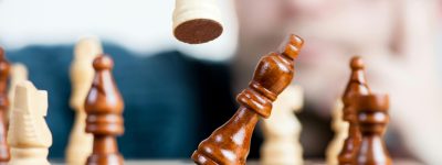 Close-up of a chess game with a focused player, emphasizing strategy and competition.